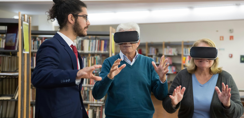 Young librarian with older patrons using AR tech