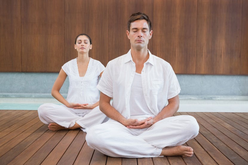 Couple doing yoga at a health spa