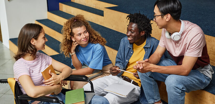 diverse-group-of-students-talking-in-library 