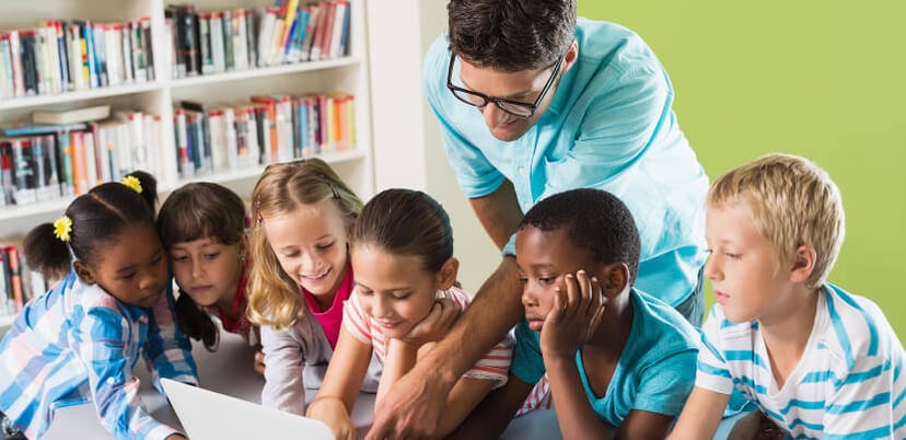 librarian-and-kids-using-laptop-in-library