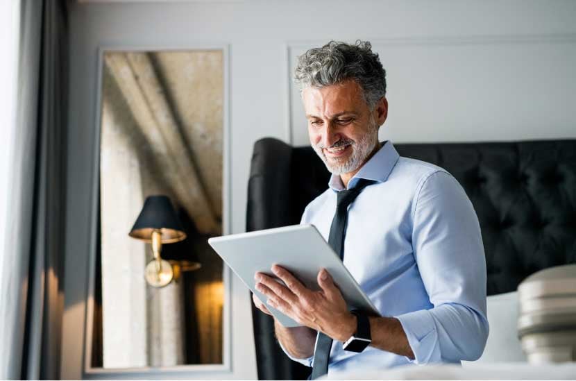 mature businessman with tablet in a hotel room