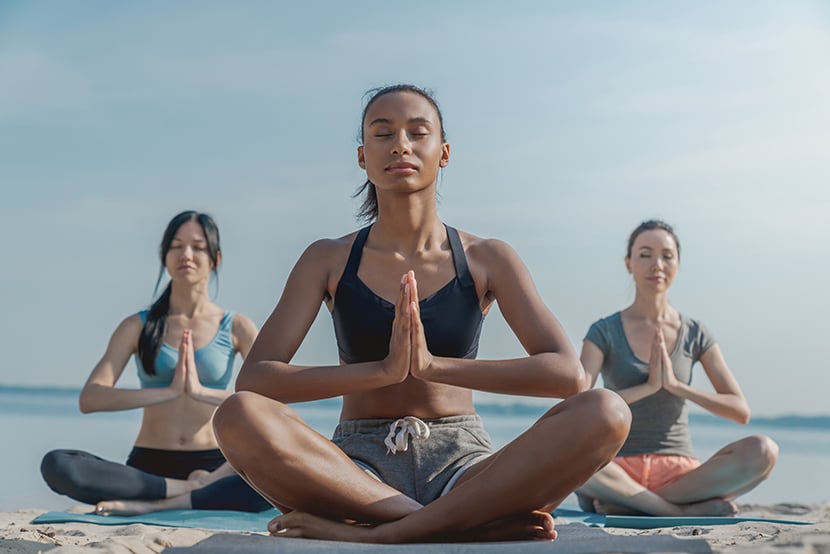 three-women-in-fitness-wear-doing-yoga-and-meditat-2022-04-19-23-07-36-utc 2