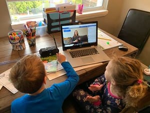 Two young children participating in Virtual Storytime through on a laptop. The storytime is hosted by Vancouver Public Library.