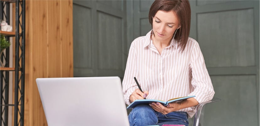woman-doing-work-using-desktop-and-writing-pad