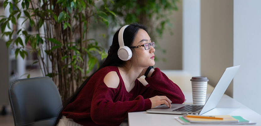 woman-on-headphones-at-computer-in-library