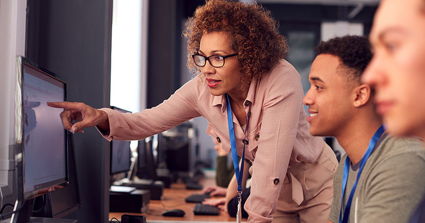 female teacher and male student looking at a screen