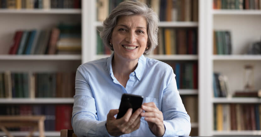older-woman-using-phone-at-library