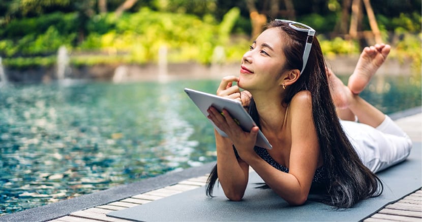 woman-on-vacation-by-pool-with-tablet